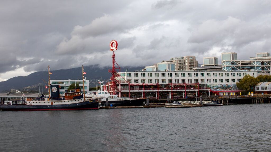 A view of two ships docked at the wharf in Lonsdale Quay market. Mountains seen in the background