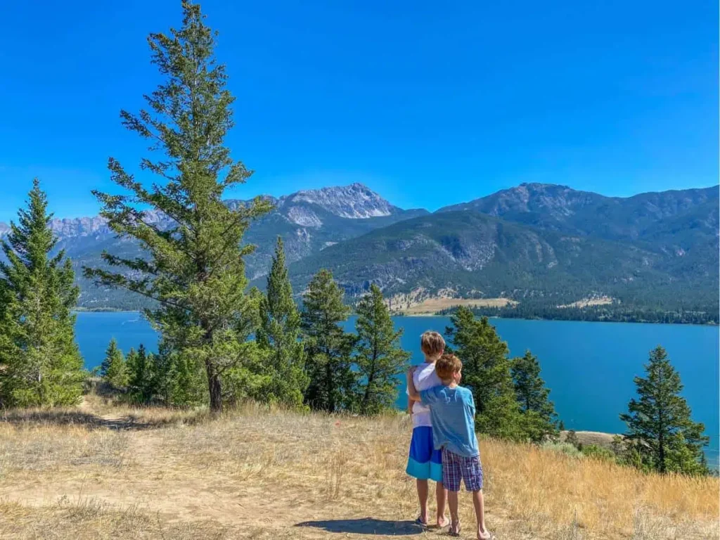 boys hugging looking out at lake and mountains