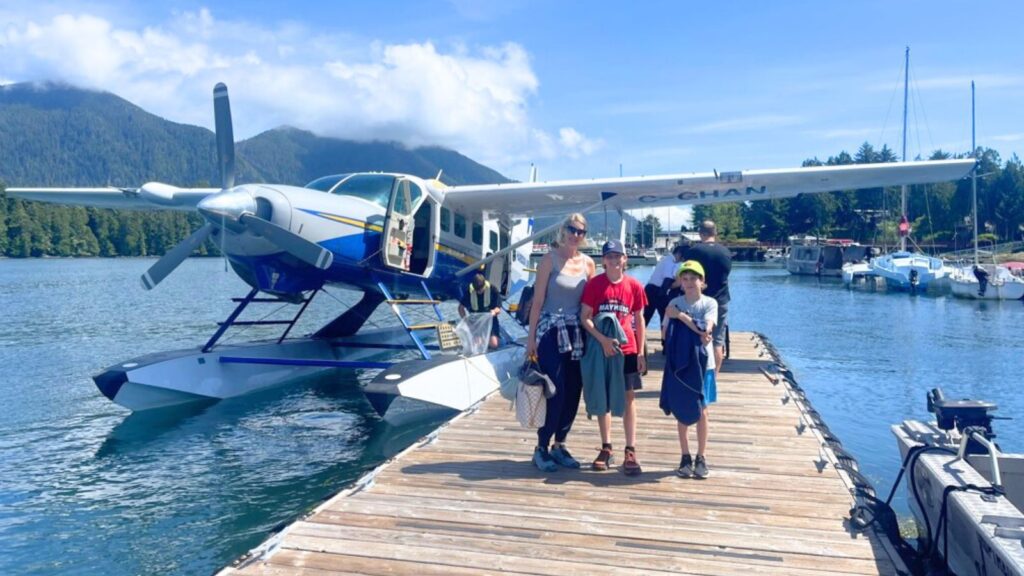 family standing on dock next to float plane in tofino