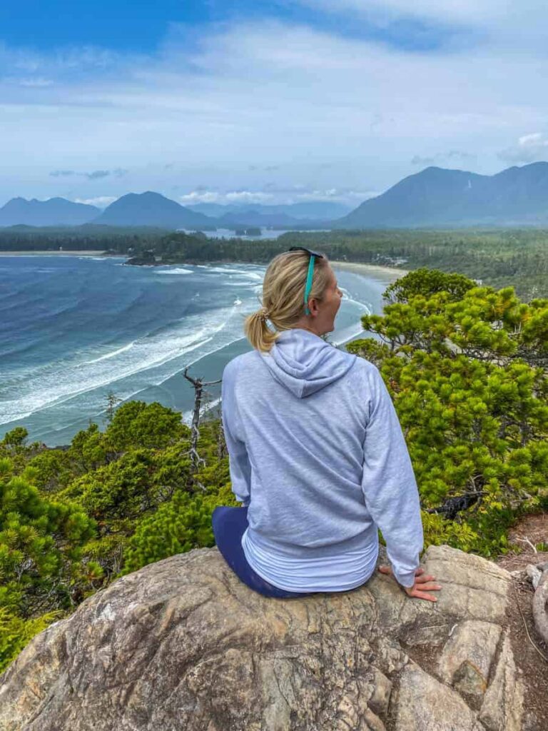 woman sitting on rock overlooking ocean