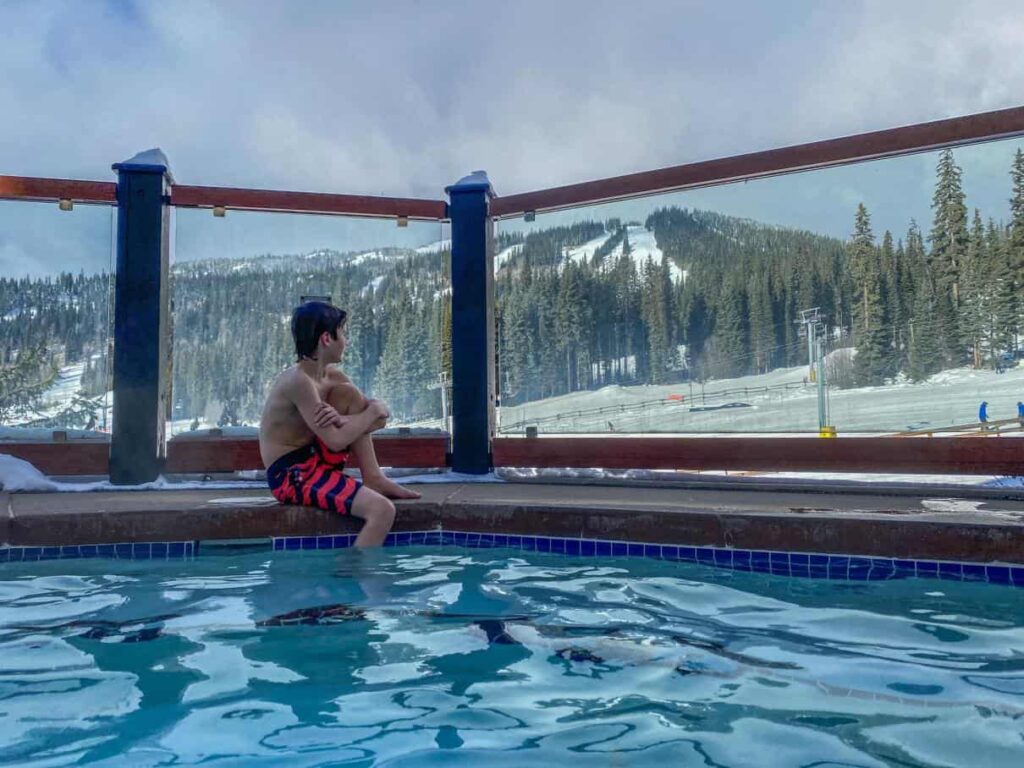 boy sitting on edge of hot tub