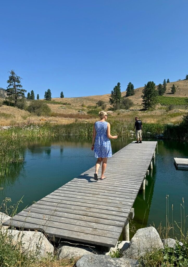 woman walking on dock with wine glass in hand