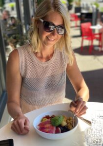 blonde woman with sunglasses smiling at lunch