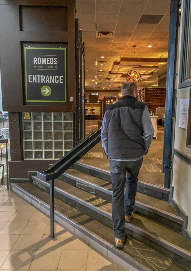 man walking up stairs to romeos restaurant